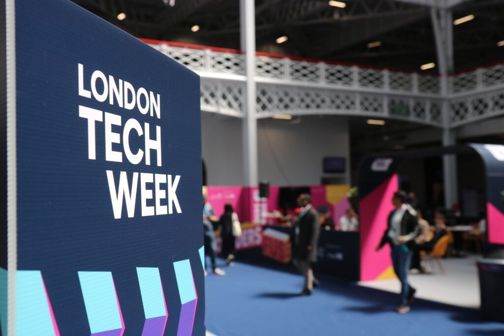 Vibrant indoor scene at London Tech Week with attendees and colorful displays.